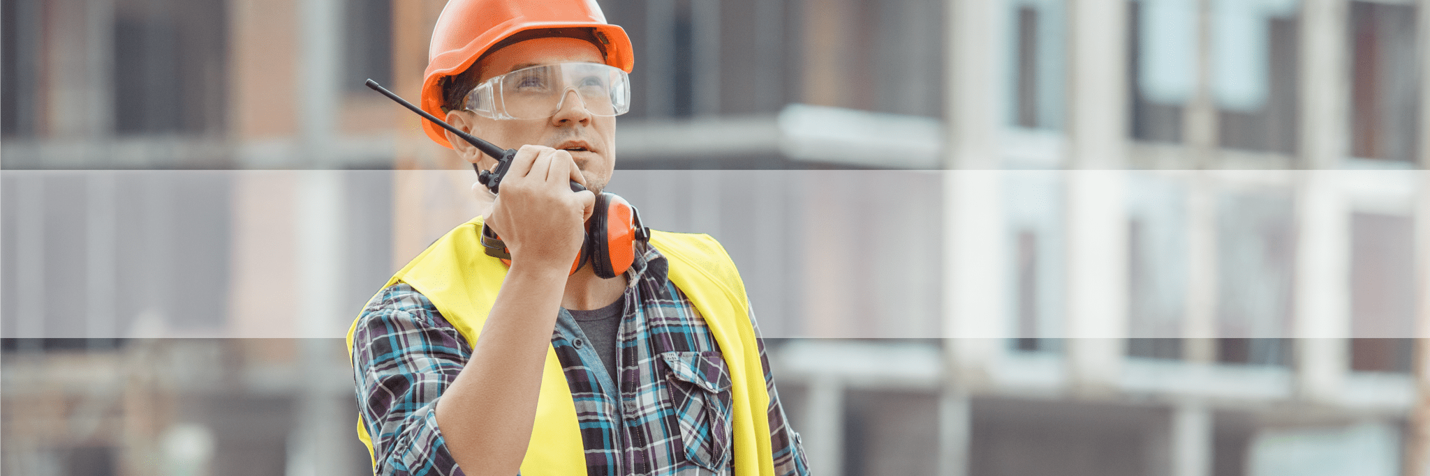 Construction worker using two way radio on work site